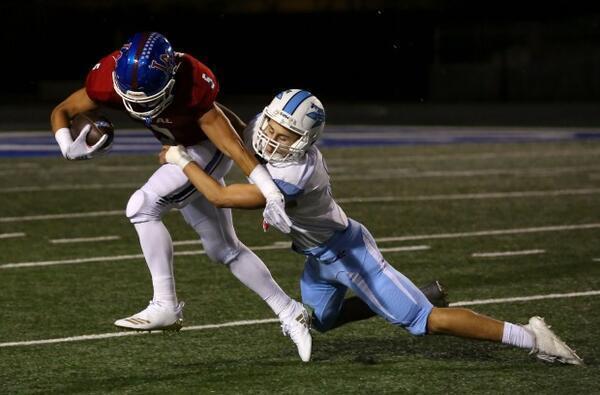 Los Alamitos Keanu Norman tries to break free from Corona Del Mar's Jack Elliott as the two teams battle it out Friday night, October 12, 2018 in Cerritos. (Photo by Tracey Roman, Contributing Photographer)
