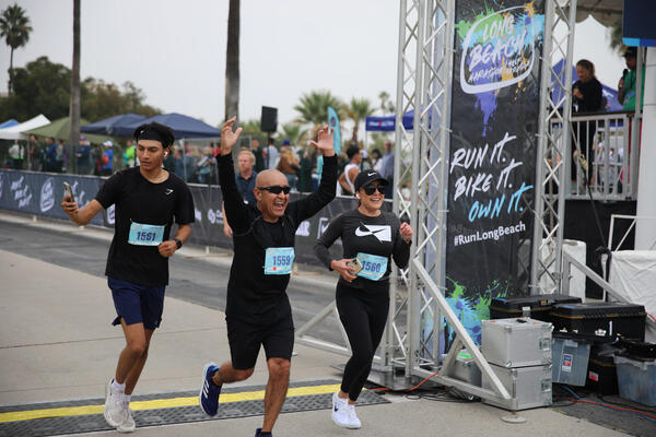 Runners cross the finish line on Shoreline Drive on Sunday,...