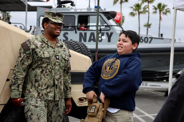 Andrew Braunstein, 5, from Beaumont, picks up a Navy vest...