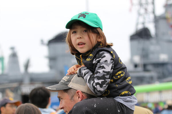 Sevyn Maggard, 5, observes the action atop his father’s shoulders...